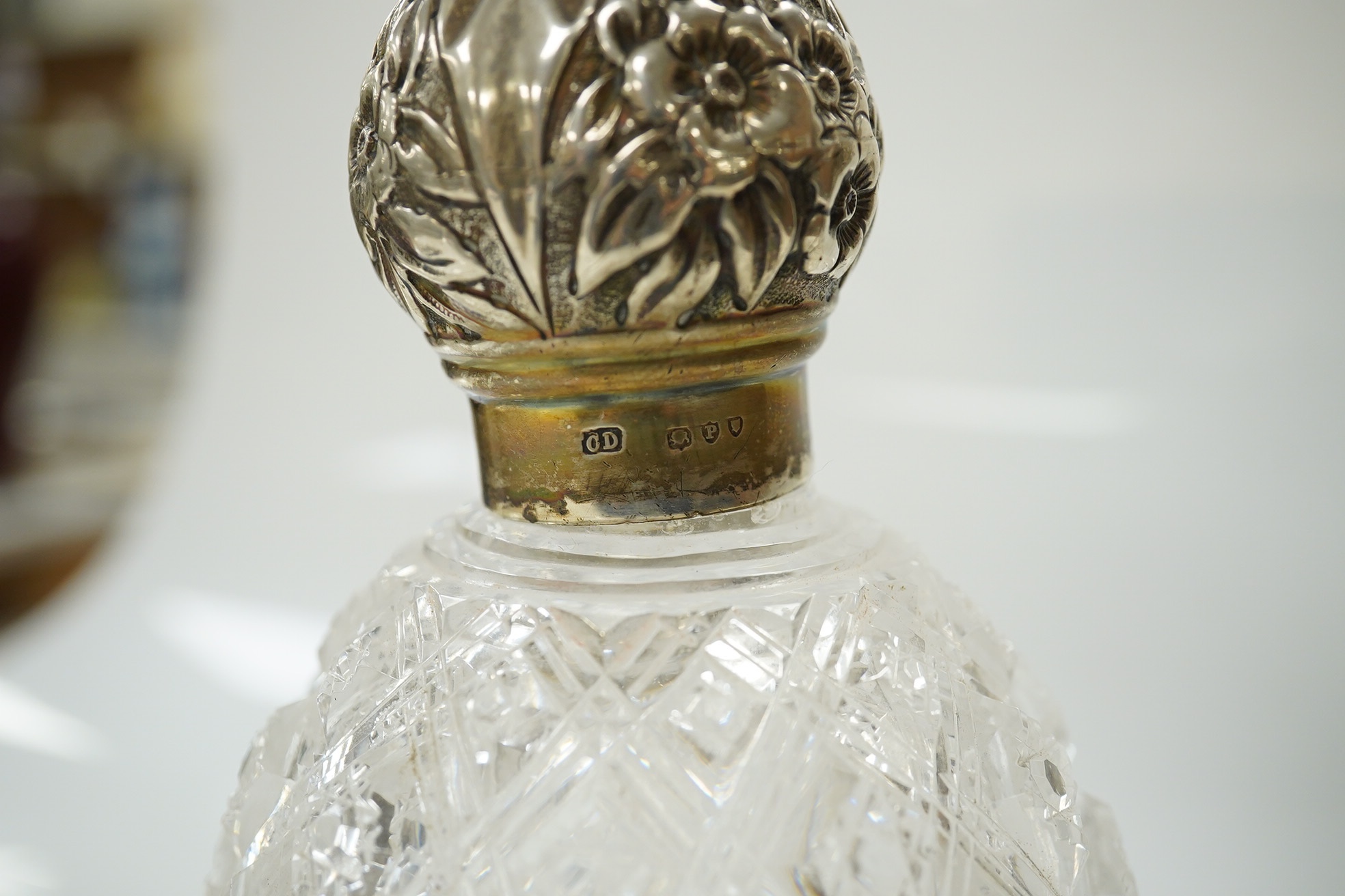 A Victorian silver lidded cut glass scent bottle, 15cm and a pair of silver collared scent bottles and stoppers, 20cm high. Condition - fair